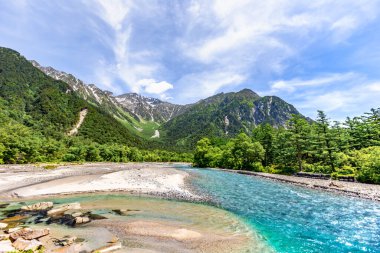 Dağları ve mavi gökyüzü olan güzel bir manzara.