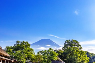 Mavi gökyüzü ve bulutlu akçaağaç yapraklı Fuji Dağı 'nın güzel manzarası