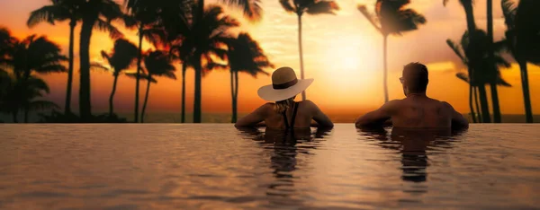 トロピカルアイランドリゾートホテルのインフィニティプールから夕日を楽しむカップル ロマンチックなビーチ休暇の休日 コピースペースのバナー — ストック写真