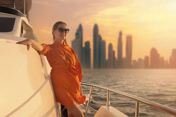 Woman Orange Dress Luxury Yacht Deck Dubai Skyline Background Sunset — Stock Fotó