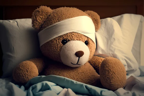teddy bear with head bandage laying in bed