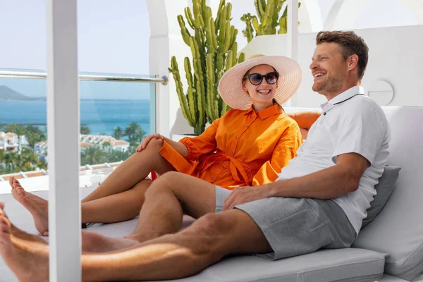 在日光浴中放松的一对微笑的夫妇 在豪华别墅的阳台享受暑假 — 图库照片