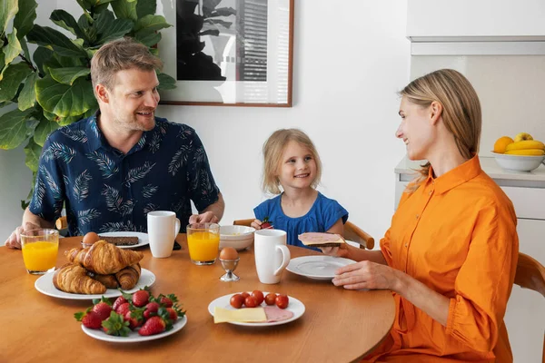 家族の朝食だ 朝の家庭のキッチンで食事をする親と子供 — ストック写真