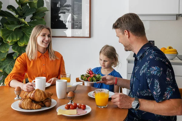 Familia Joven Feliz Con Niño Comiendo Desayuno Saludable Junto Mesa —  Fotos de Stock