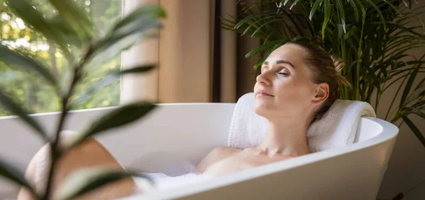 Mulher Relaxante Banheira Com Olhos Fechados Banheiro Com Plantas Tropicais — Fotografia de Stock