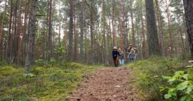 Aktif ve çocuklu bir aile dışarıda eğleniyor. Orman yolunda koşmak