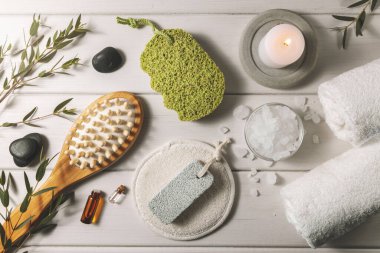 Beyaz ahşap masadaki banyo malzemelerinin kompozisyonu. Spa ve sağlık merkezi. en üstteki görünüm