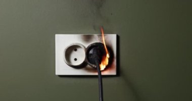 Evin kısa devre kablosuyla elektrik prizini yakmak. Evde yangın güvenliği ve aşırı güç kullanımı kavramı. kaydırıcı atışı