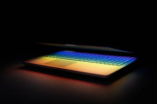 Półzamknięty Laptop Ciemnym Stole Kolorowym Odbiciem Światła Klawiaturze Zdjęcia Stockowe bez tantiem