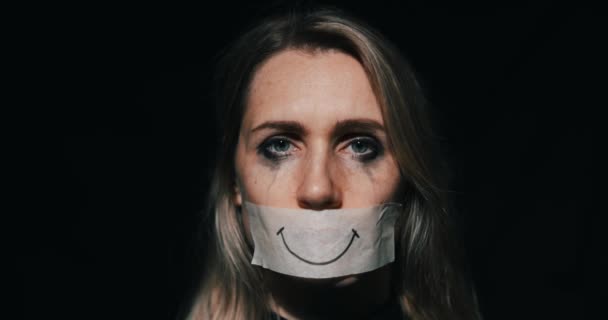 虐待和家庭暴力 忧郁的女人把嘴藏在纸带上虚假的微笑后面 抑郁症和精神健康 — 图库视频影像