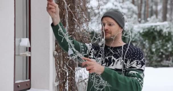 Homem Desembaraçar Luzes Natal Livre Para Casa Decoração Exterior — Vídeo de Stock
