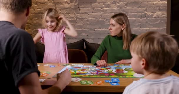 Οικογένεια Που Διασκεδάζει Παίζοντας Επιτραπέζια Παιχνίδια Στο Σπίτι Κόρη Ρίχνει — Αρχείο Βίντεο