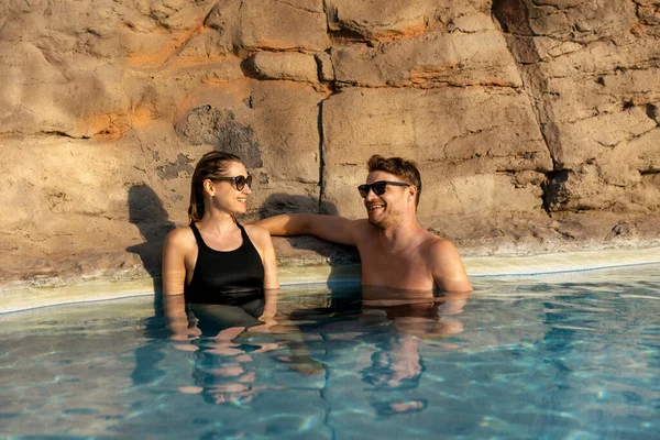 一对微笑的夫妇在温泉游泳池里放松地在一起 浪漫的逃跑 图库图片