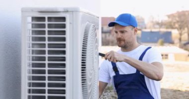 Teknisyen havalandırma ya da hava pompası üzerinde çalışıyor. HVAC servisi, bakım ve onarım