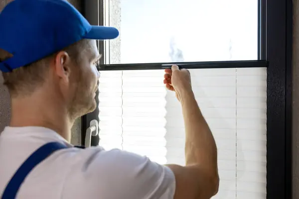 Arbeiter Montiert Plissee Jalousien Fenster lizenzfreie Stockbilder
