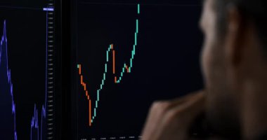 Bilgisayar ekranında dijital mum çubuğu verilerini analiz eden kripto para birimi yatırımcısı. Borsa komisyoncusu takas platformu indekslerine bakıyor. omuz görünümü