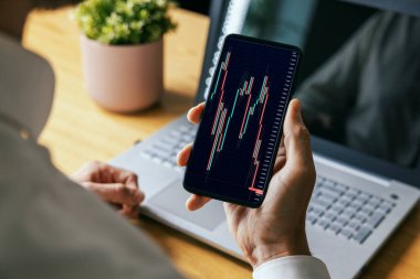 Adam cep telefonundan online kripto ya da borsa veri tablolarına bakıyor. blockchain dijital varlık ve ETF yatırım kavramı