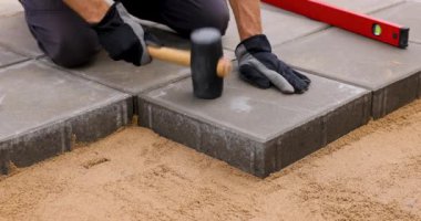 Kauçuk çekiçle beton döşeyen işçiler