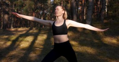 Güneşli bir ormanda pilates yapan bir kadın. Zihin-vücut egzersizleri