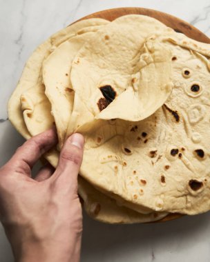 Soft lavash bread on white background. Homemade freshy baked lavash bread is perfect for kebabs, shawarma and other dishes. Only water, yeast, flour and salt. High quality photo