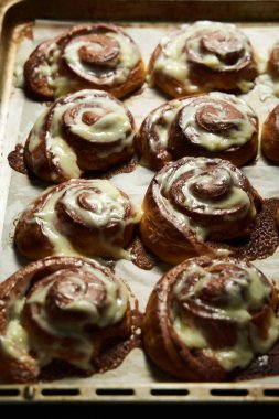 Cinnabon rolls on rustic baking sheet glazed with cream cheese. Freshly baked. High quality photo