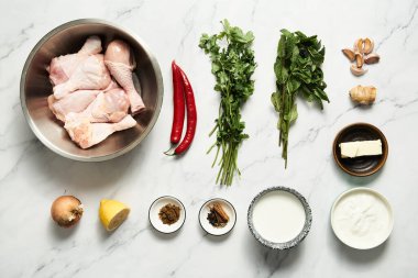Hand holds afghani chicken in spicy sauce with cream and yogurt. Cucumber and sour cream salad on the background. High quality photo