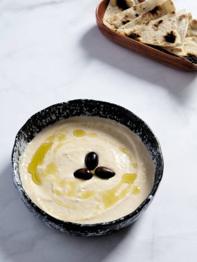 Taramasalata in the bowl with olive oil and black olive. Taramasalata is a Greek spread and meze made from tarama, the salted and cured roe of the cod. High quality photo