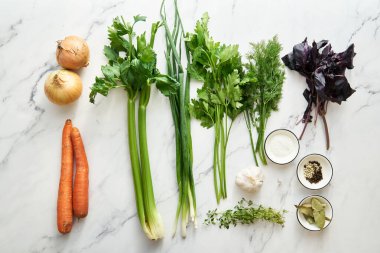 Vegetable stock in glass bowl. Ingredients of stock on the background. High quality photo
