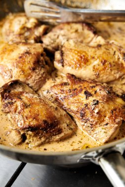 Browned Chicken Thighs Moroccan style. Chicken thighs in creamy gravy from heavy cream with garlic and ginger and other spices. High quality photo