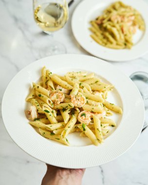 Pasta with shrimps, garlic, lemon and parsley. Penne with shelled shrimps. High quality photo