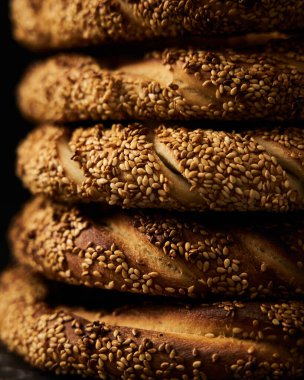 Close up ofTurkish simit bread pretzels stack. Homemade Sesame bagel on dark background. Low key, dark photo High quality photo