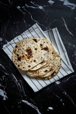 Pan roasted pita bread on dark background. Top view. High quality photo