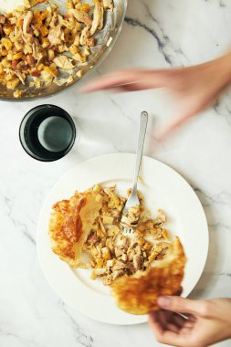 Mans hand over the plate with fall open chicken pie with celery, onions, chicken and creamy sauce. Motion blurred. High quality photo