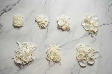 Farklı soğan dilimleri. Fotoğrafta küçük zardan büyük zarlara farklı soğan kesikleri gösteriliyor. Halkalar, parçalar ve yarım ay dilimi artı jülyen. Yüksek kalite fotoğraf