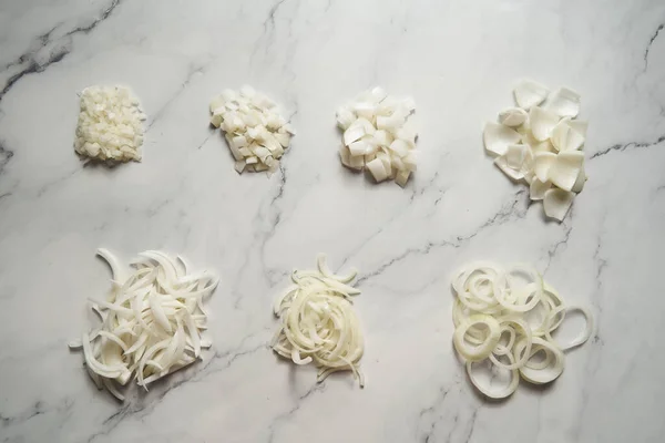 Farklı soğan dilimleri. Fotoğrafta küçük zardan büyük zarlara farklı soğan kesikleri gösteriliyor. Halkalar, parçalar ve yarım ay dilimi artı jülyen. Yüksek kalite fotoğraf