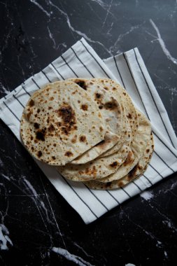 Pan roasted pita bread on dark background. Top view. High quality photo
