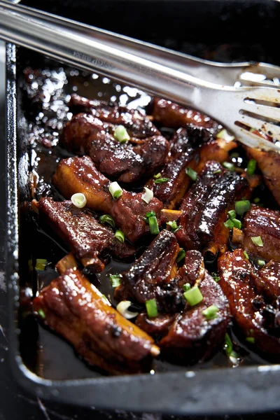 Soy glazed bbq pork ribs decorated with green onions. Sticky, juicy and delicious. High quality photo