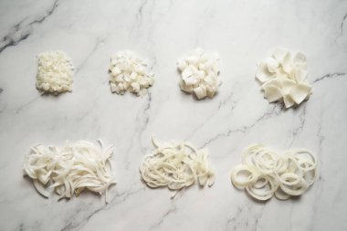 Farklı soğan dilimleri. Fotoğrafta küçük zardan büyük zarlara farklı soğan kesikleri gösteriliyor. Halkalar, parçalar ve yarım ay dilimi artı jülyen. Yüksek kalite fotoğraf