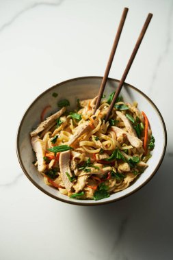 Sağlıklı Tayland tavuklu erişte salatası. Aisan mutfağı. Tavuk ve sebzeli taze ve soğuk haşlanmış pirinç eriştesi ve soya, balık ve sarımsak ve zencefilli tatlı biber sosuna dayalı sos ve şeker.