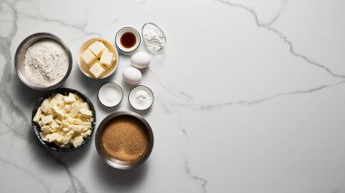 Beyaz mermer arka planda sarı malzemeler. Şekerli ve tereyağlı beyaz çikolata, yumurta. Vanilya özü ve un. Uzayı kopyala Yüksek kalite fotoğraf