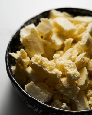 Siyah bir seramik kasede kırılmış beyaz çikolata. Sarışın yapmanın ana malzemesi. Beyaz mermer arka plan. Kapatın. Yüksek kalite fotoğraf