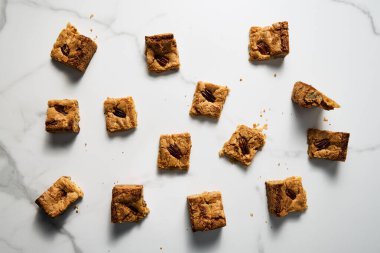 Beyaz mermer tezgahta sarı kurabiyelerin üst görüntüsü. Beyaz çikolata tatlı ve lezzetli, çiğnenmiş kurabiyeler. Yüksek kalite fotoğraf