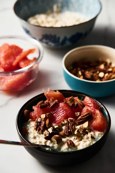 Overnight oats with milk and greek yogurt ingredients list. healthy breakfast with nuts with grapefruit, honey and cinnamon. High quality photo