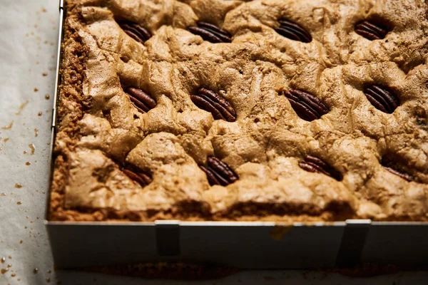 Uncuted Blondie with pecan nuts after baking. White chocolate sweet and tasty, chewy cookie bars.. High quality photo