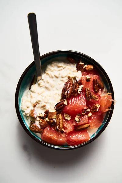Overnight oats with milk and greek yogurt ingredients list. healthy breakfast with nuts with grapefruit, honey and cinnamon. Top view. High quality photo
