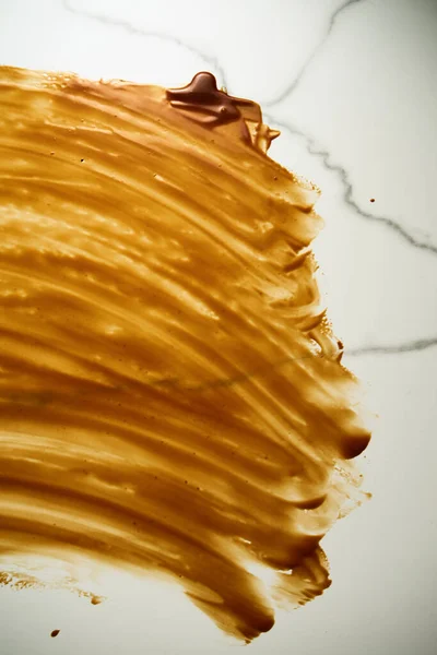 Salted Caramel sauce smeared on the tabletop. A tabletop stained with caramel. Thin layer, copyspace. Top view food photo. High quality photo