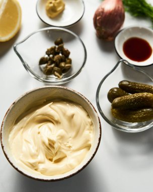 Beyaz mermer arka planda klasik Tatar sosu malzemeleri. Dereotlu mayonez ve kapari artı limon, soğanlı soğan. Worcester sosu ve Dijon Hardalı. Yüksek Kalite Yemek Fotoğrafı