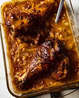 Hindi kanatlarını dikdörtgen pişirme kalıbında boğmuş. Yemek fotoğrafı. Kıtır kıtır kızartılmış, kanatları kalın bir sosun içinde sebzelerle boğulmuş. - Evet. Yüksek kalite fotoğraf