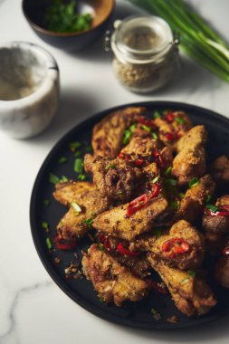 Çin tuzu ve biberli tavuk kanadı. Kızarmış tavuk kanadı, tuzlu ve biberli sebzeler ve soğan, sarımsak ve biberle çabucak sotelendi. Yüksek kalite