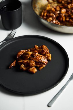 Tavuk Tocino. Yapışkan tatlı jöleli tavuk. Karamelli tavuk butları siyah tabakta tatlı soslu. Yüksek kalite fotoğraf
